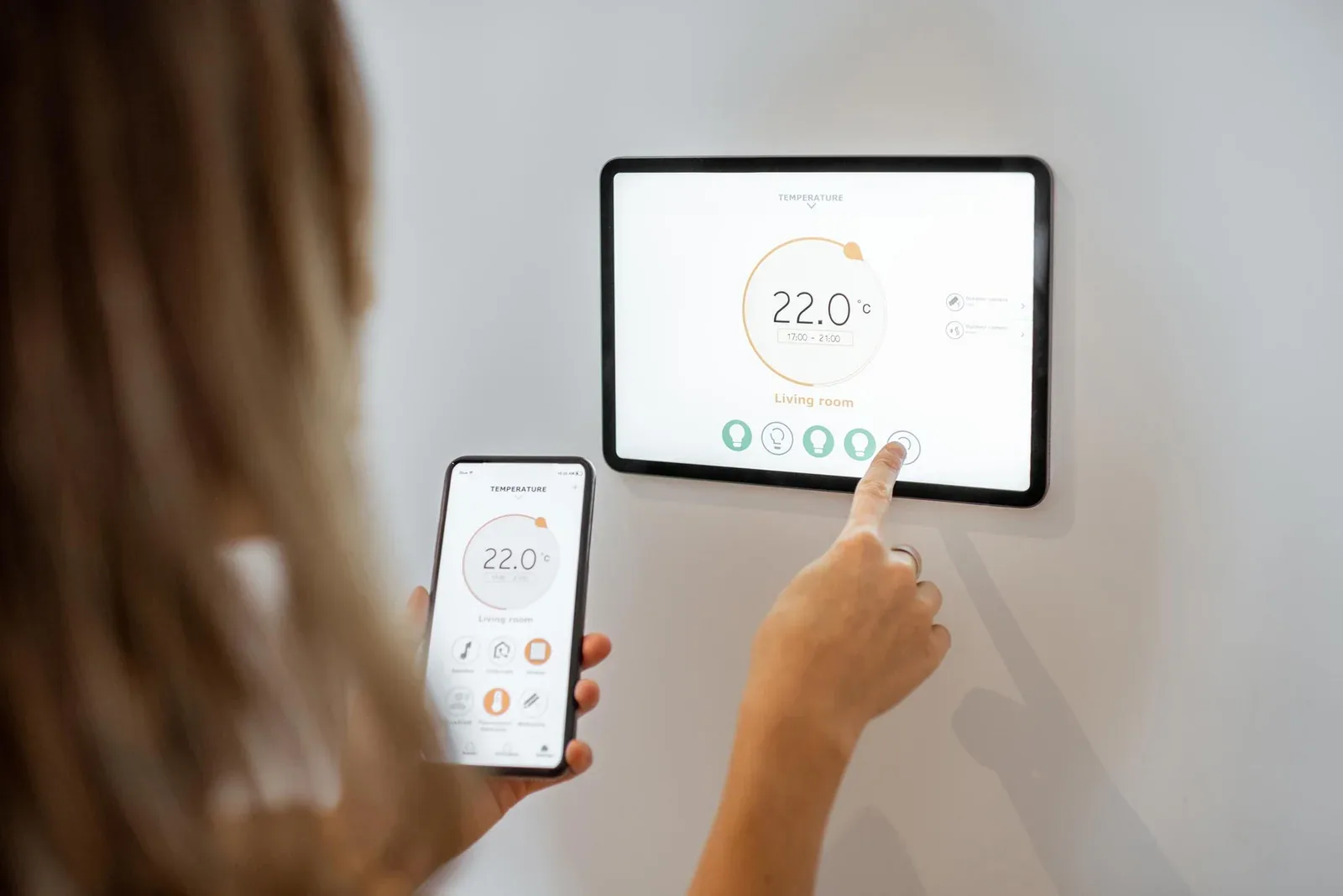 Homeowner adjusting a smart heating control on a wall panel